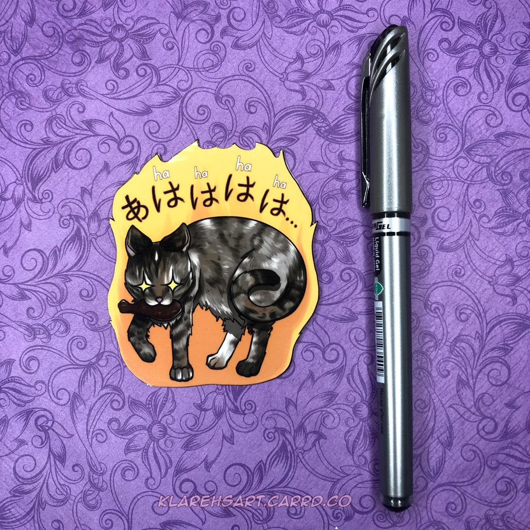 Vinyl sticker of a grey brown cat stealing a chicken drummy in its mouth, eyes sparkling with mischief. A yellow anime blaze surrounds the cat with "Ha ha ha" above its head. The sticker is on a purple background. An ink pen to its right shows the size comparison.