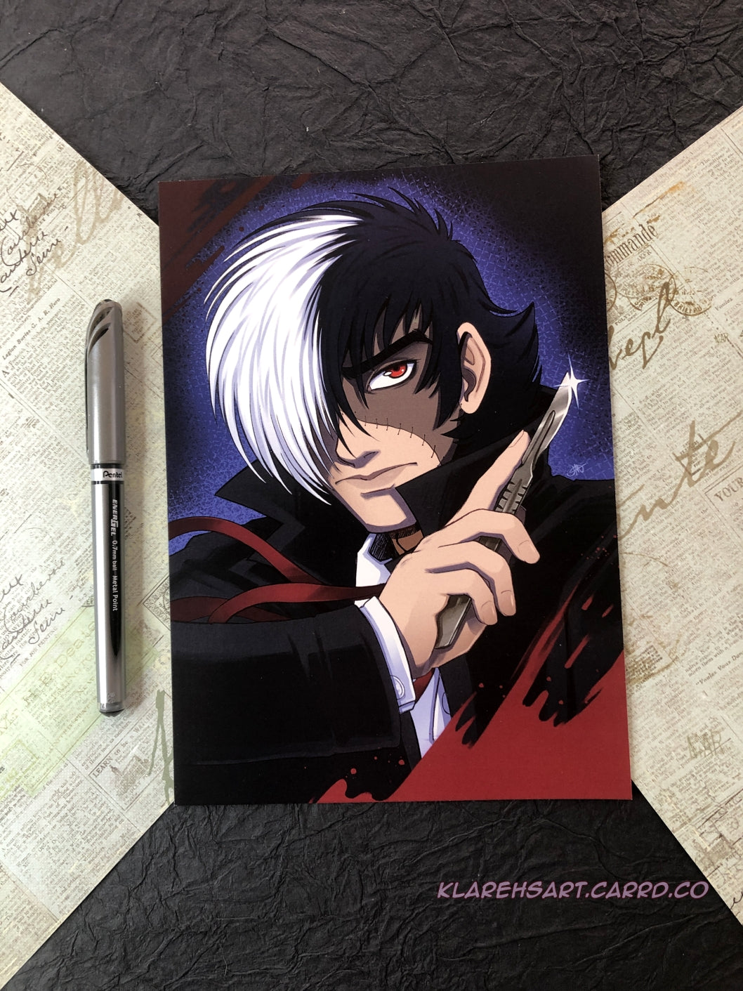 Anime character with white and black hair and red eyes, half of his face is stitched with another skin tone. He is holding a scalpel, wearing a black trench coat with a white shirt and red string tie. A blood splat accents the corner. The ink pen shows size comparison. This is Medium size.