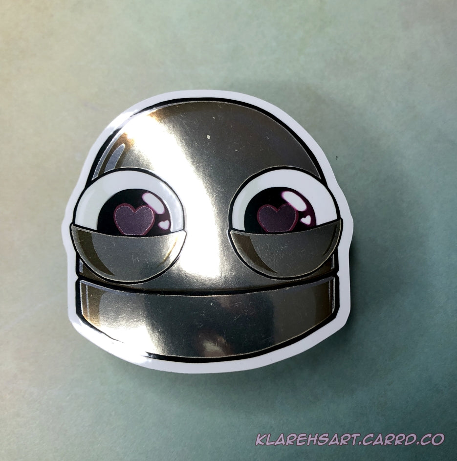 Metallic gold robot sticker with heart-shaped eyes on a light green background