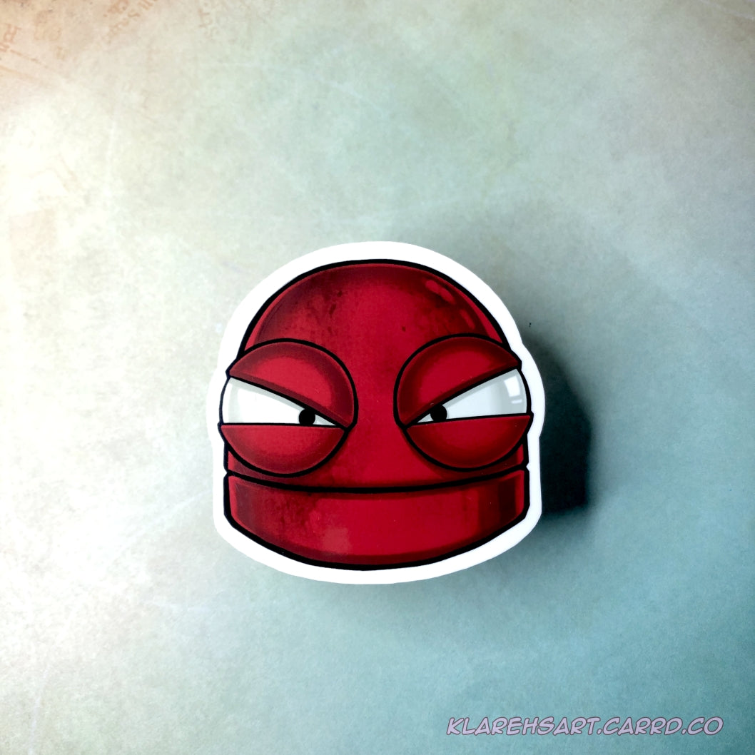 A vinyl sticker of a red robot with a mad expression. On a light gold and green background.