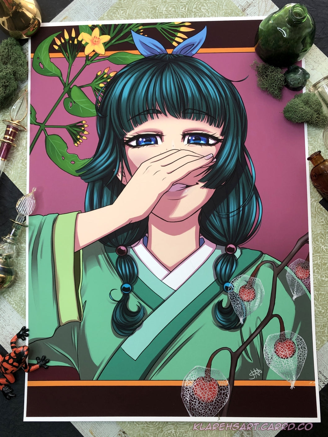 Illustration of an apothecary with dark green hair in beads and a ribbon. She has blue eyes and covering her smirk with her right hand. She is wearing green and white clothing. Poisonous plants frame her. This is the Large size.