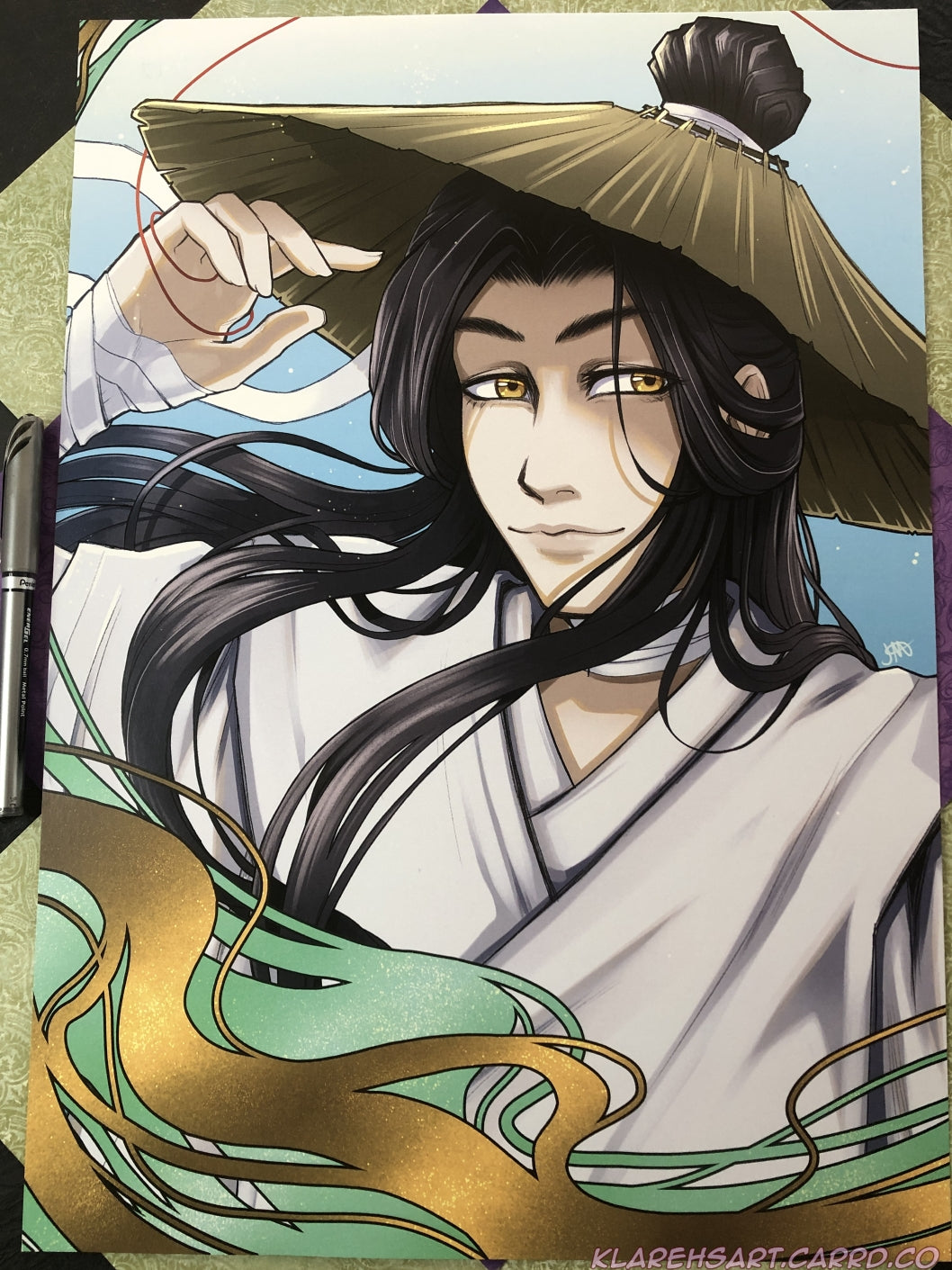 Illustration of a smiling man with long black hair, golden eyes, straw hat and white daopao robes. The pen on the left shows size comparison. This is the large size.